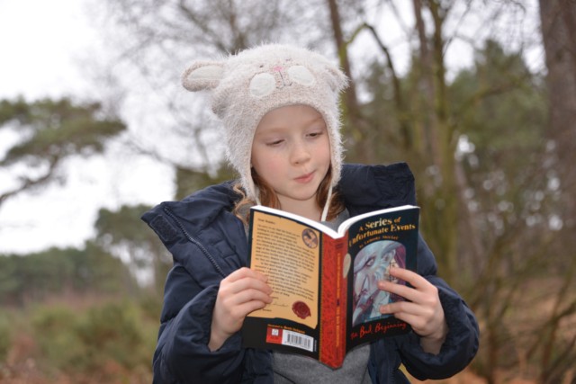 child reading in the forest