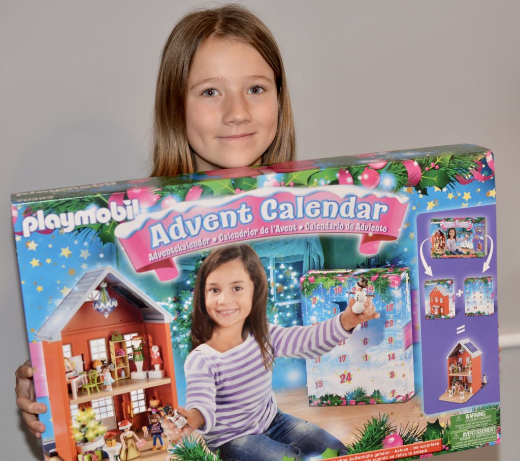 Girl holding Playmobil advent Calendar