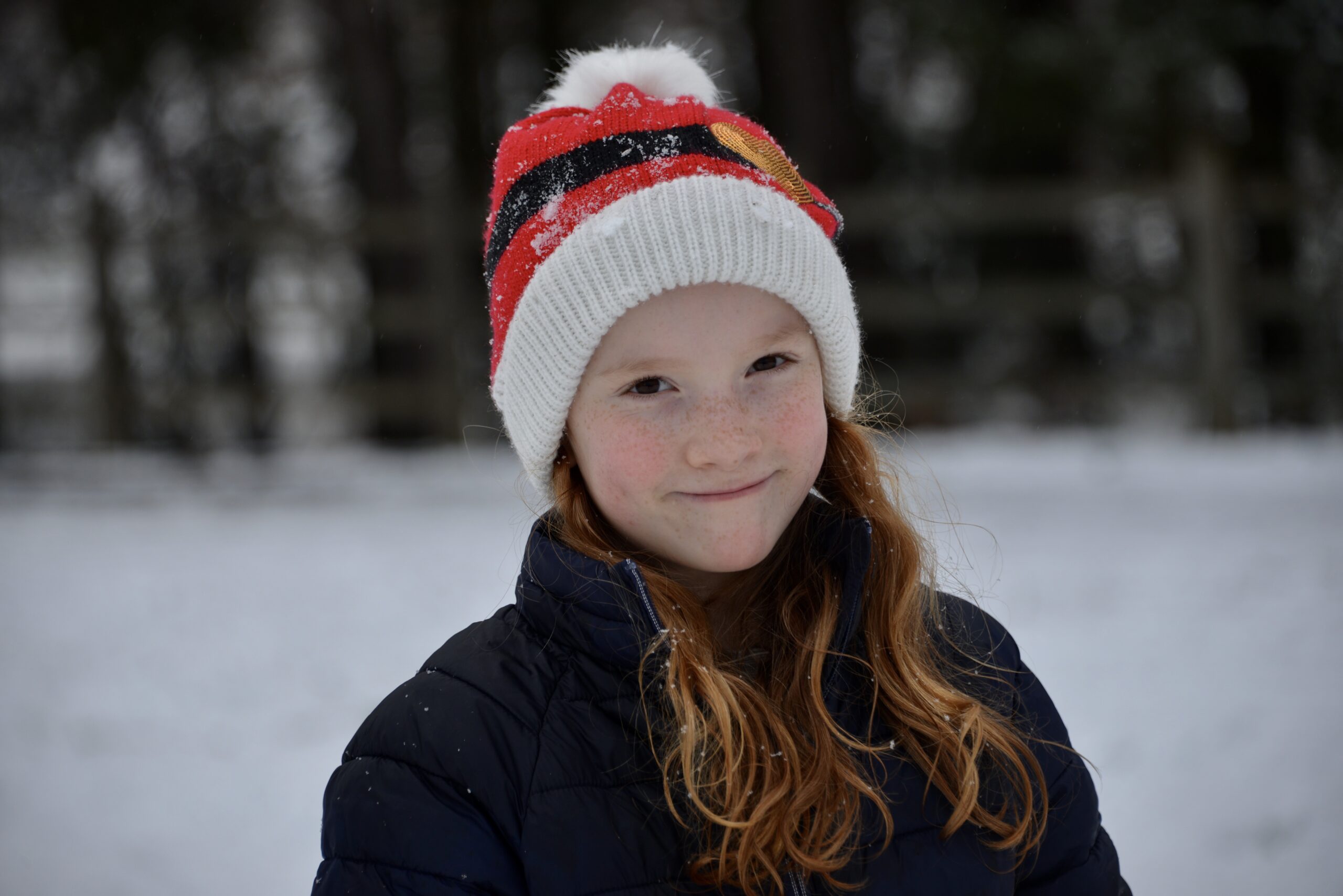 Child in the snow wearing a christmas hat