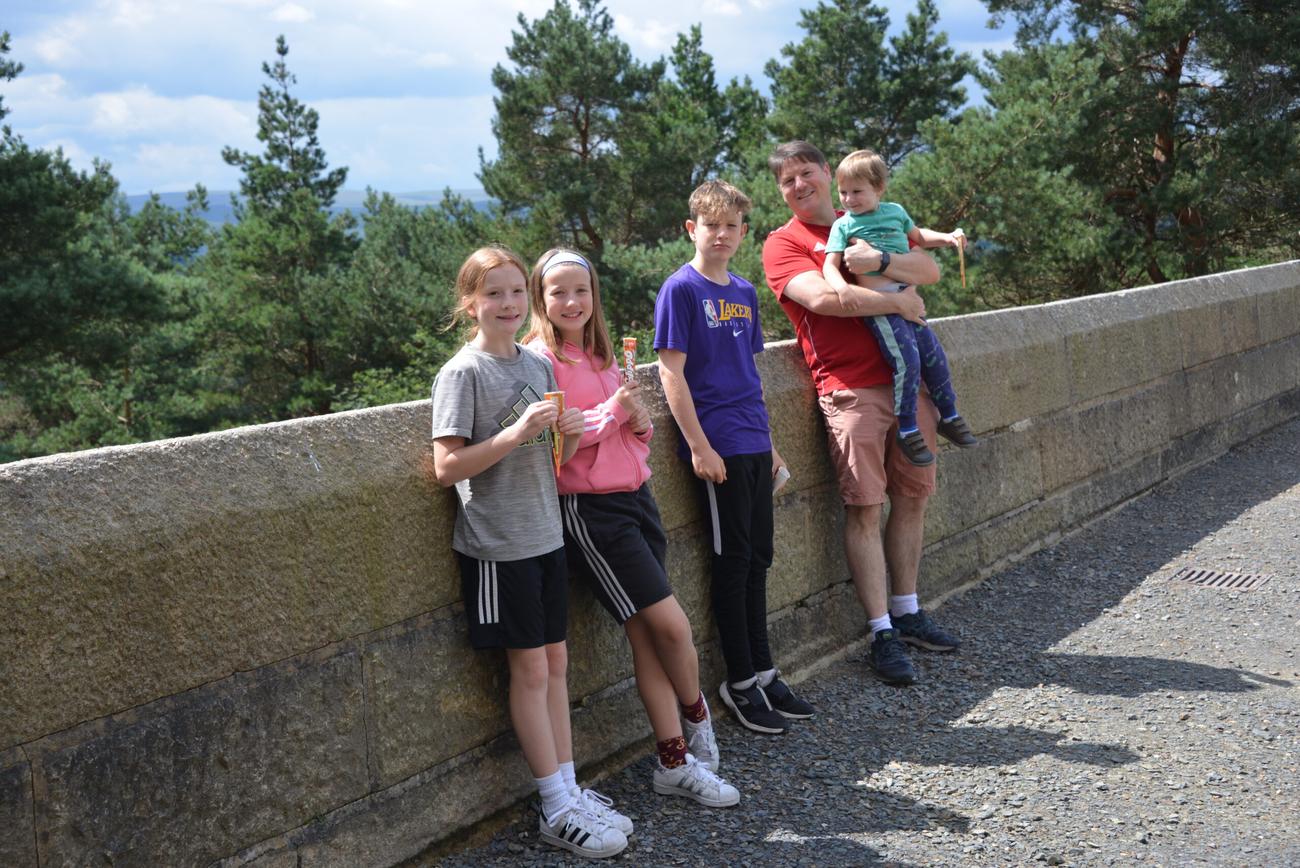 Family leaning against a wall at Castle Drogo