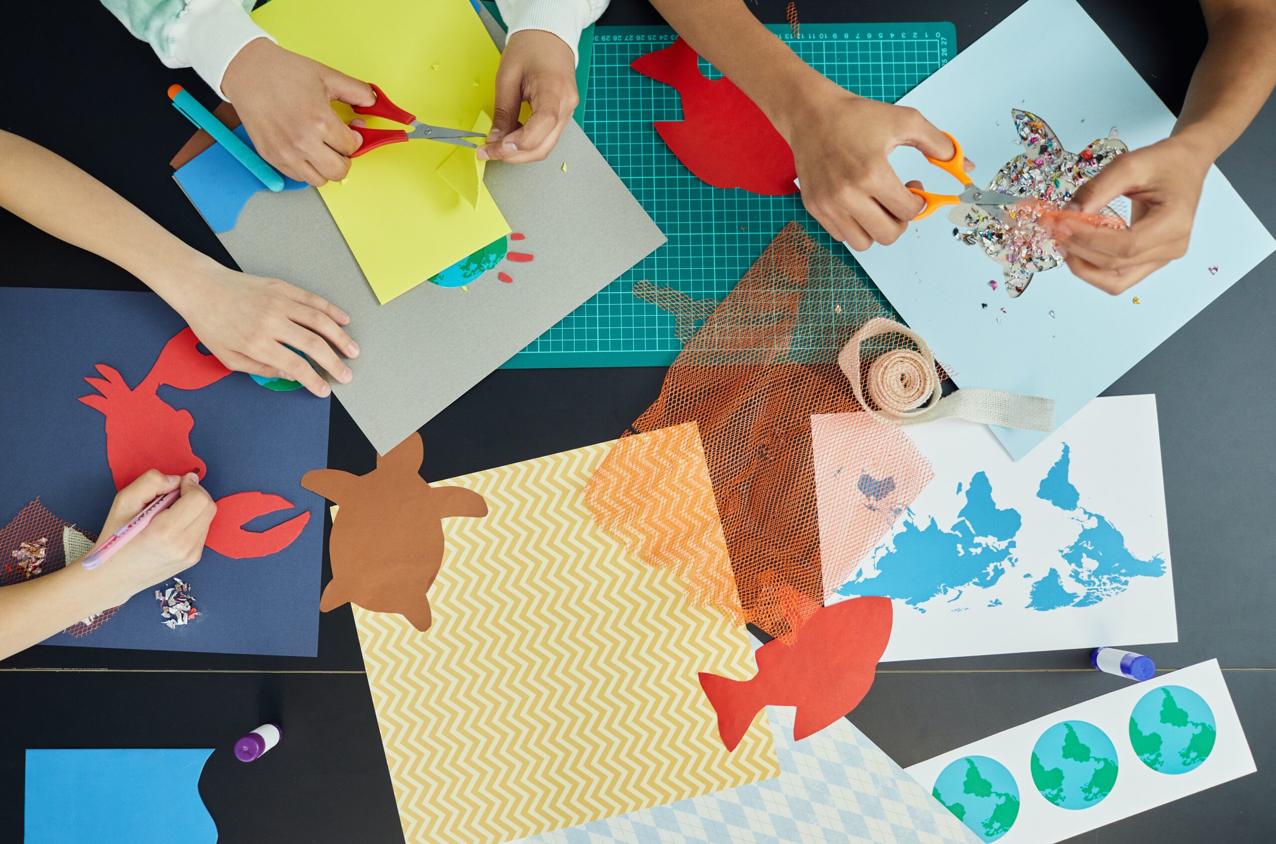 children creating crafts on a black table