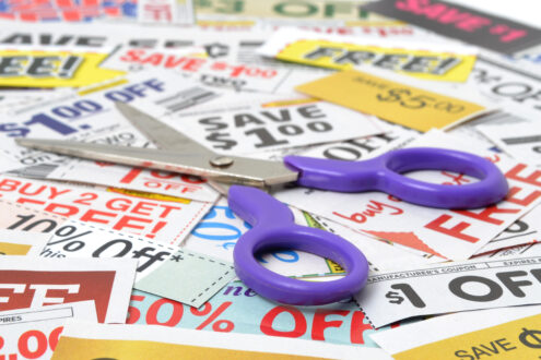 a pile fo coupons for shopping with scissors on top