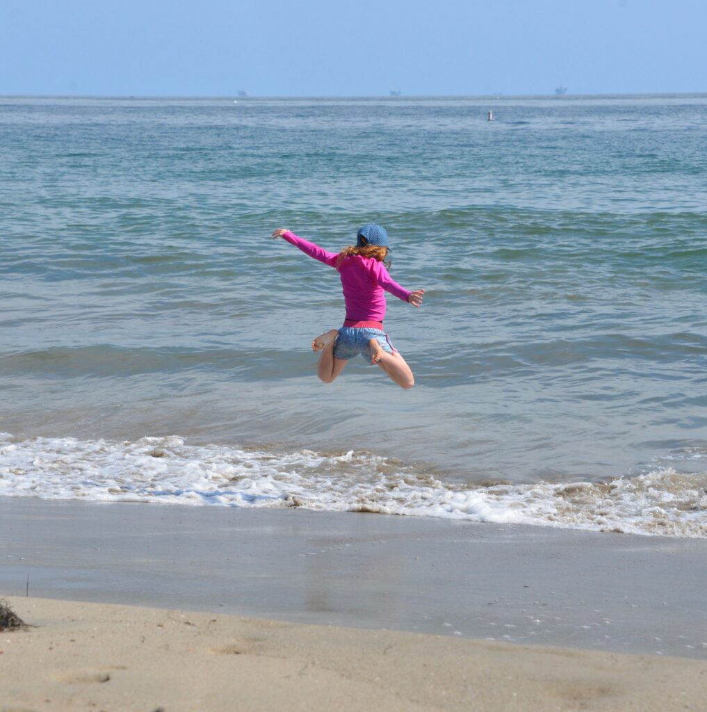 girl jumping by the sea in Santa Barbara