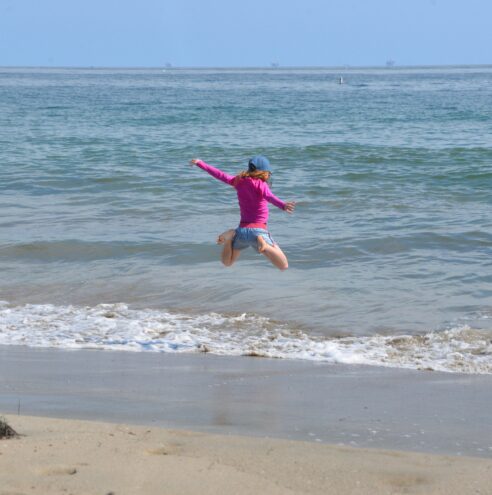 girl jumping by the sea in Santa Barbara