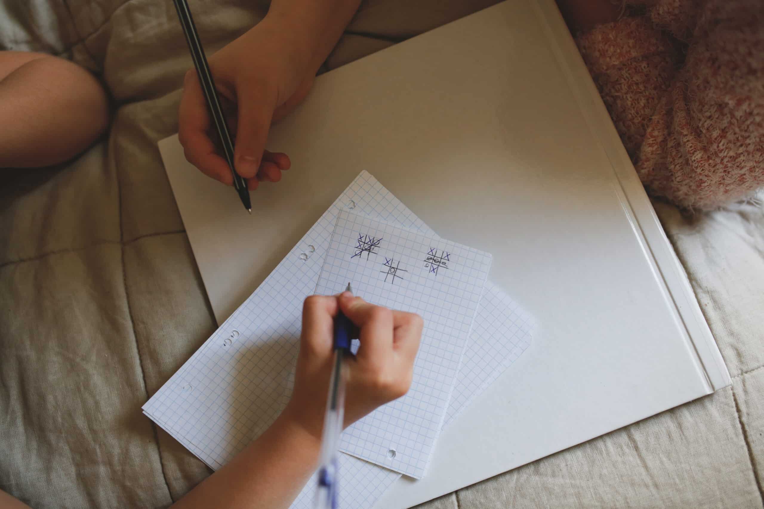 children playing tic tac toe on paper