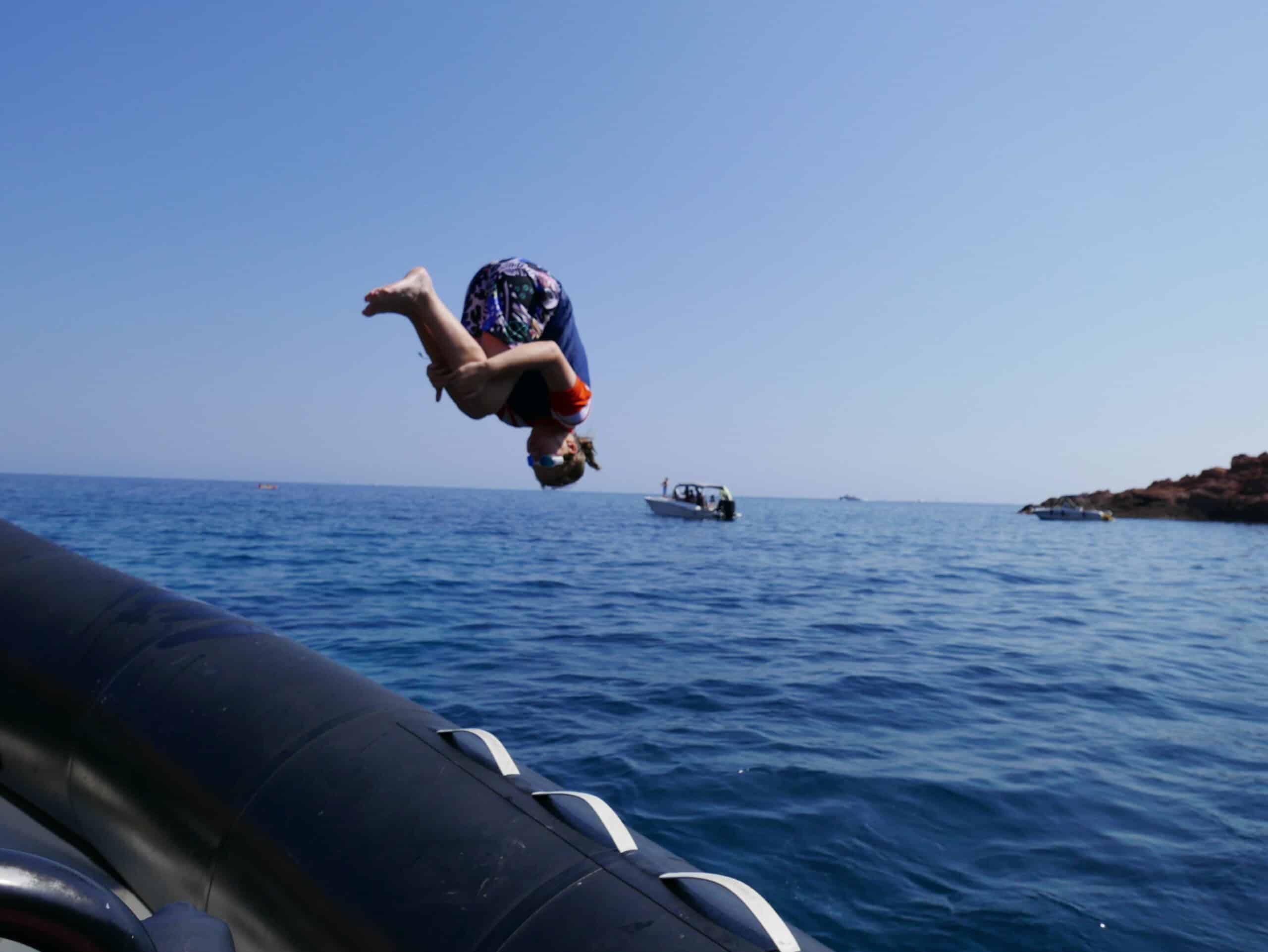 Child backflipping of a boat into the sea