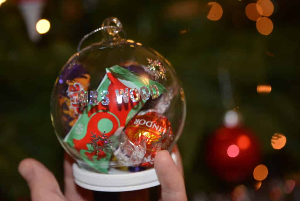 snow globe decoration filled with chocolates. The front has a name printed that has been designed and cit with a Cricut Joy