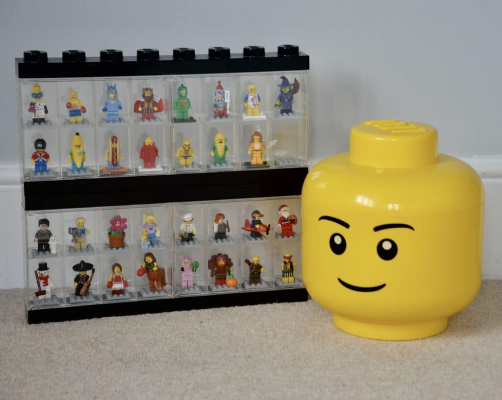 2 mini figure cases stacked on top of each other with a giant LEGO head next to them
