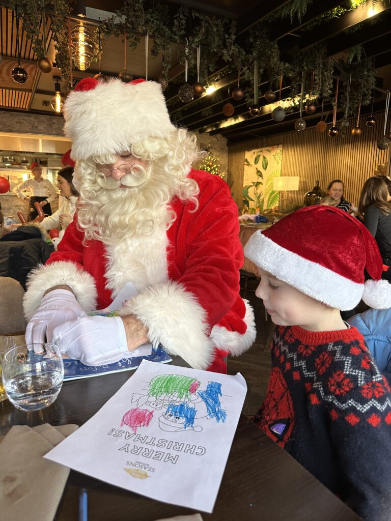 Santa at the Seasons restaurant with a little boy