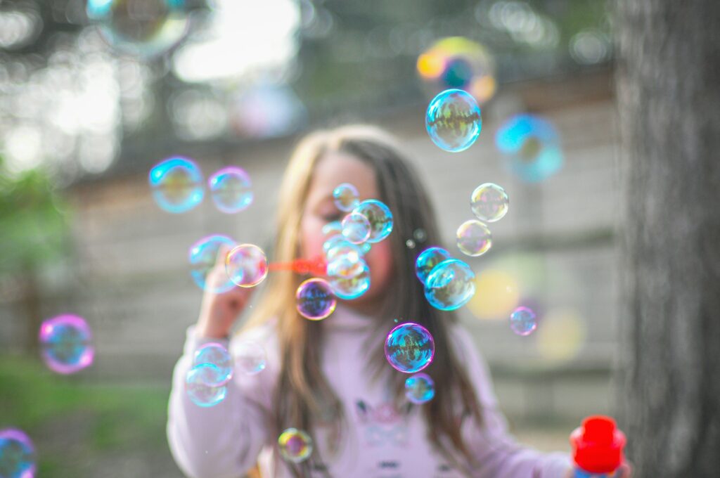 child blowing bubbles