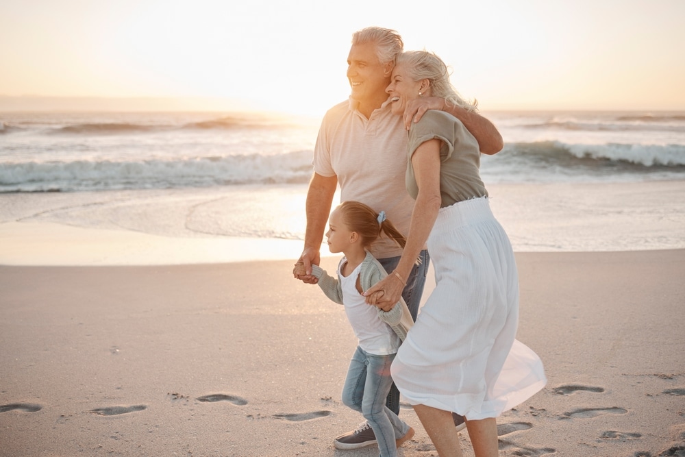 grandparents with child on a beach